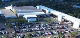 a imagem mostra uma vista aérea dos anexos do TRE-BA. Em frente aos prédios, há um amplo estacio...