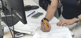 assinando um documento sobre uma mesa.