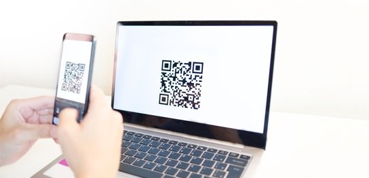 QR code PIX Imagem de um celular escaneando um QR code na tela de um computador.